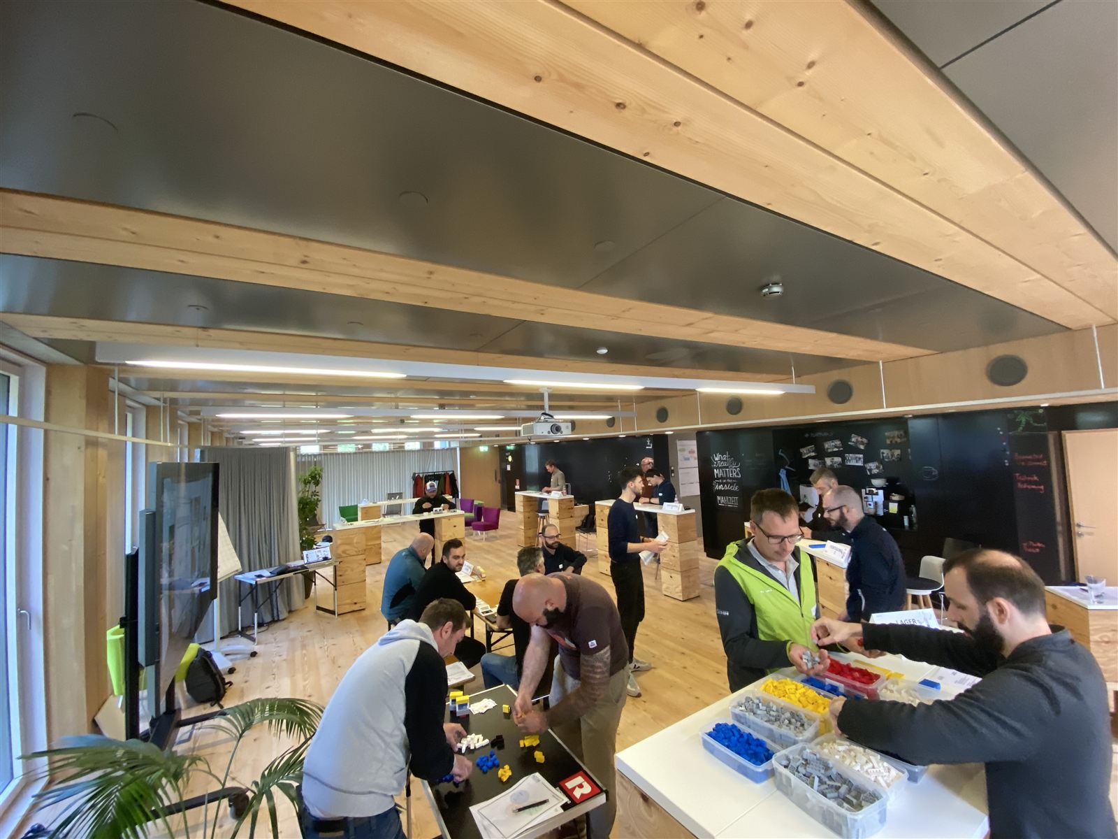 Prozess-Simulation im WoodRocks Büro: Mitarbeitende bauen Bauabläufe mit Modellbausteinen nach