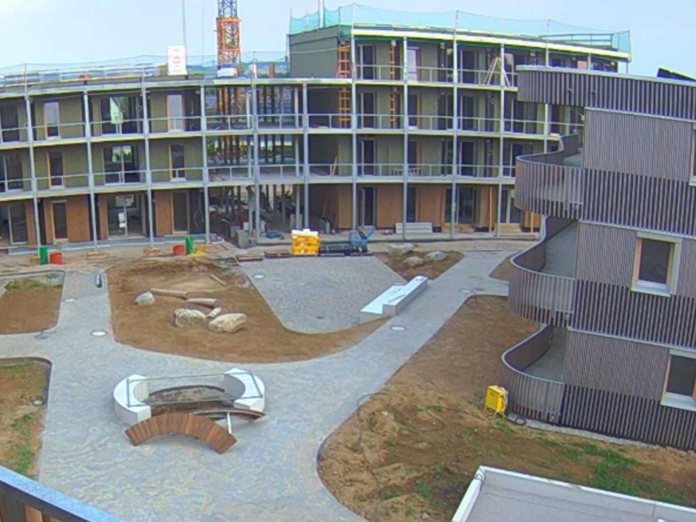 Baustelle Ulm Donaustetten aus der Baustellenkamera: Innenhof mit zwei Wohngebäuden im Rohbau, Gerüst und Kran